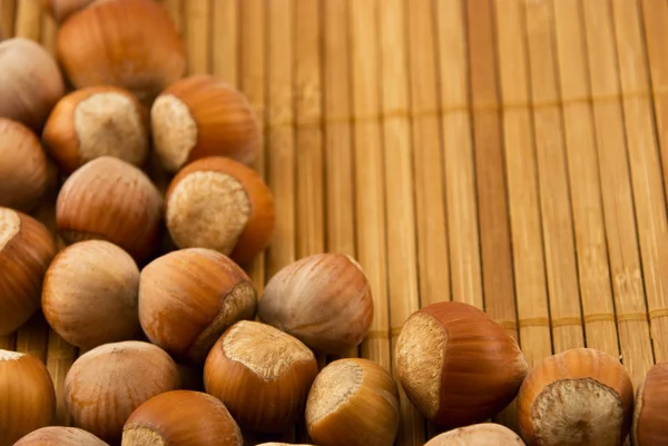 Nocciole isolate su un tappetino di bambù — Foto Stock