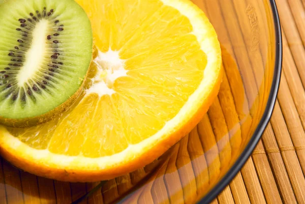 Apelsin och kiwi frukt på en tallrik — Stockfoto