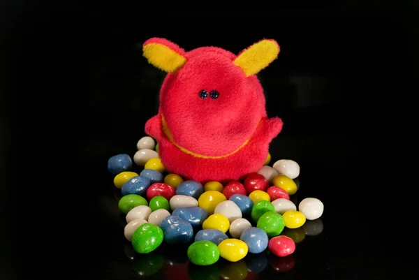 Brinquedos e doces em um fundo preto — Fotografia de Stock