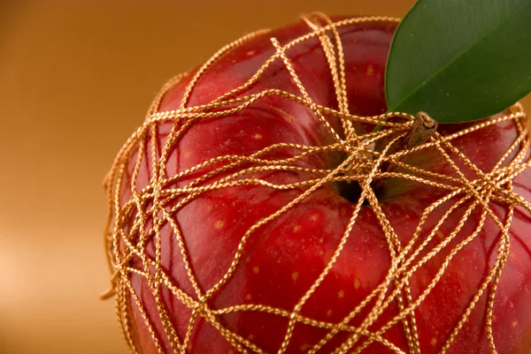 Altın arka plan üzerinde kırmızı elma — Stok fotoğraf