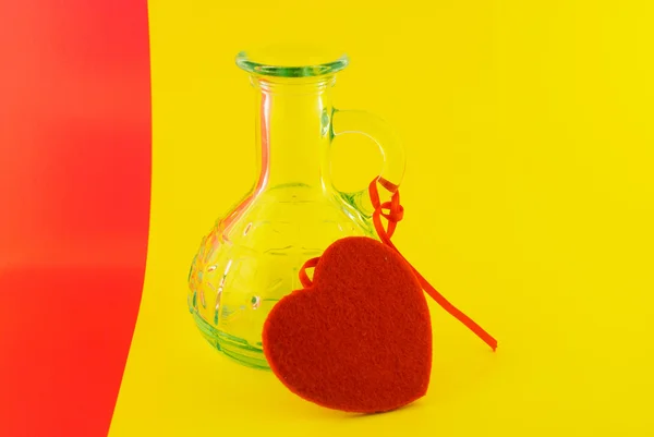 Skleněná láhev a srdce na barevném pozadí — Stock fotografie