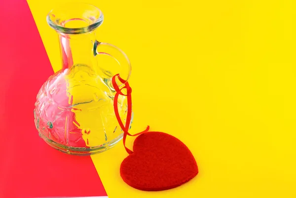 Скляна пляшка і серце на барвистому фоні — стокове фото