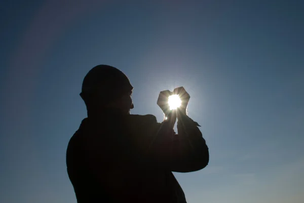 Άνθρωπος που κρατά έναν ήλιο στα χέρια του ενάντια στον ουρανό — Φωτογραφία Αρχείου
