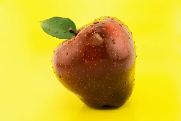 Red apple on a yellow background — Stock Photo, Image