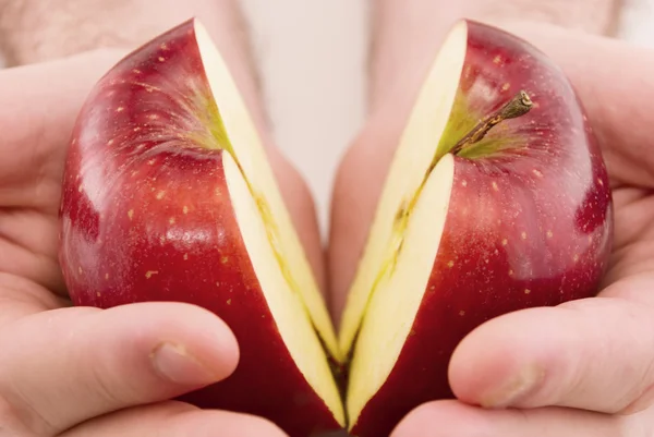 Halv ett äpple i händer isolerad på vit — Stockfoto