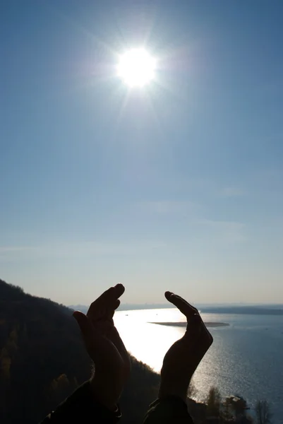 Muž, který držel slunce v jeho rukou proti obloze — Stock fotografie