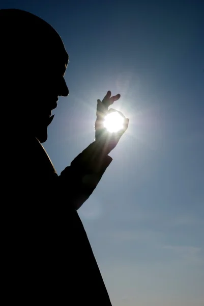Man die een zon in zijn handen tegen de hemel — Stockfoto