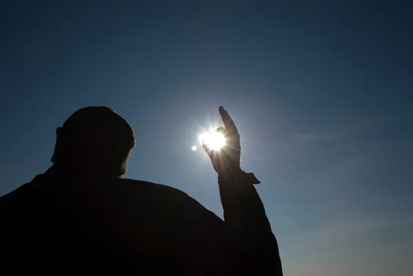 该名男子手持一个太阳在他的手对着天空 — 图库照片