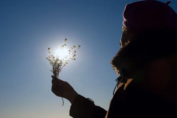 Женщина с цветком на солнце — стоковое фото
