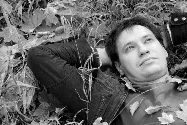 Portret mężczyzny leżącego na jesiennych liściach — Zdjęcie stockowe