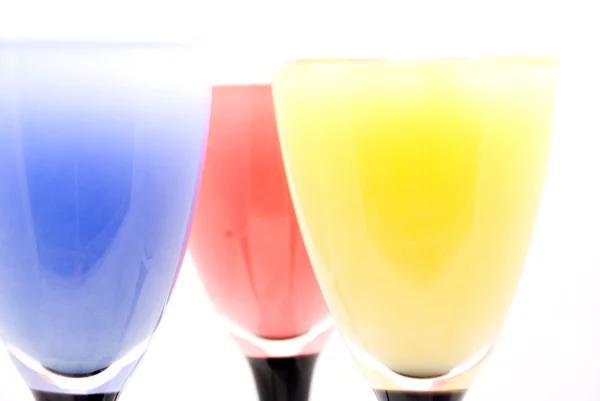 Okulary z różnych kolorowych napojów na białym tle — Zdjęcie stockowe