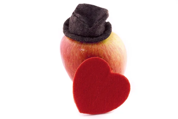 Jabłko w kapeluszu i serca na białym tle — Zdjęcie stockowe