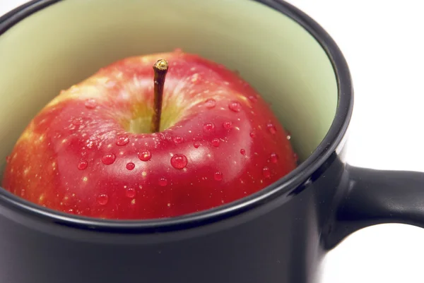 Apfel in einer Tasse isoliert auf weiß — Stockfoto