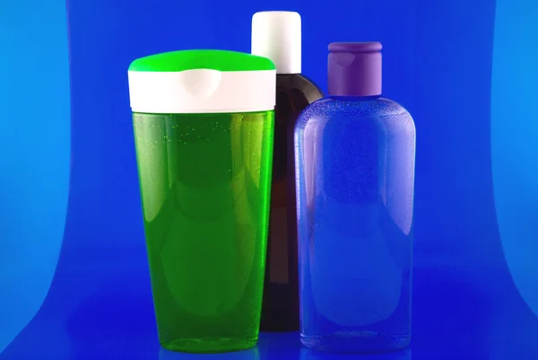 Recipientes cosméticos sobre fundo azul — Fotografia de Stock