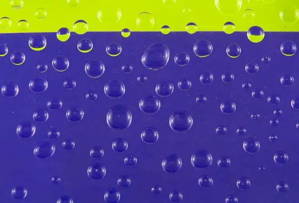 Dråber af vand på en farverig baggrund - Stock-foto