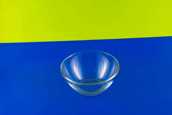 Tigela de vidro em um fundo colorido — Fotografia de Stock