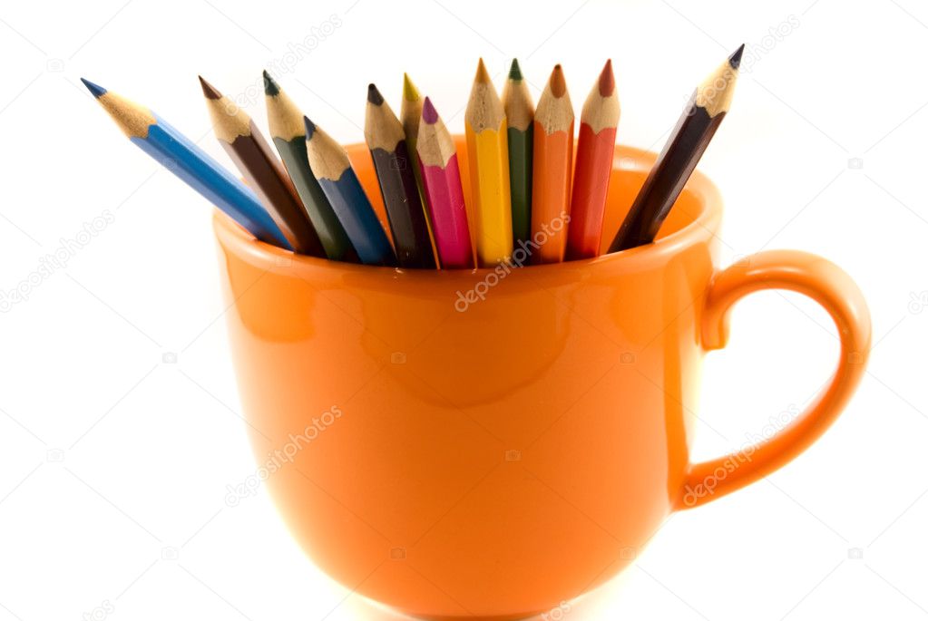 Cup with colored pencils isolated on white