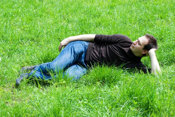 緑の草に坐っている人 — ストック写真
