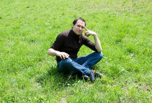 Man zit op groen gras — Stockfoto