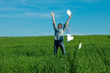 Young man throwing a paper in the green field clipart