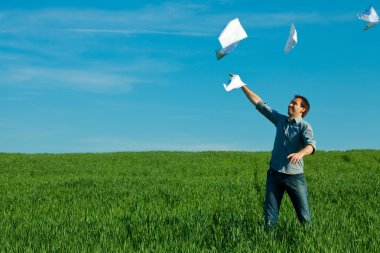 Young man throwing a paper in the green field clipart
