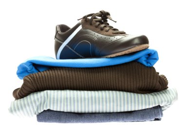 Shoes and a mountain of clothes isolated on white clipart