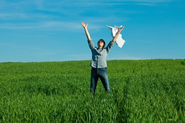 Молодий чоловік кидає папір у зелене поле — стокове фото