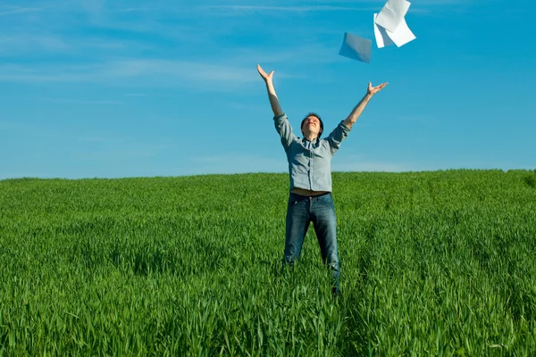 Молодий чоловік кидає папір у зелене поле — стокове фото