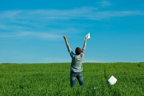 Genç adam yeşil alanında bir kağıt atma — Stok fotoğraf