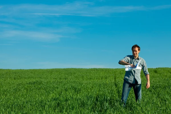 Anak muda melemparkan kertas di lapangan hijau — Stok Foto