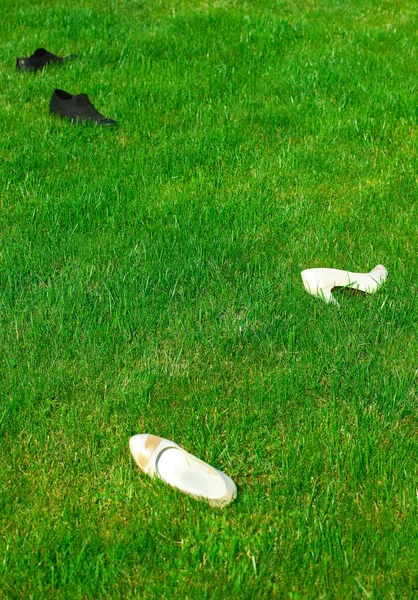 Buty panny młodej i pana młodego, leżącego na zielonej trawie — Zdjęcie stockowe