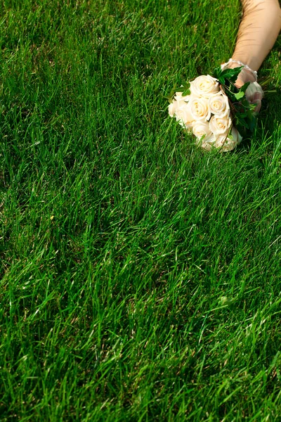 花嫁の手の緑の草の上に横たわる、ブライダル ブーケ — ストック写真