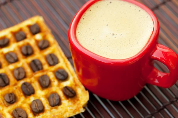 Kopje cappuccino wafels en koffie bonen op een bamboe-mat — Stockfoto