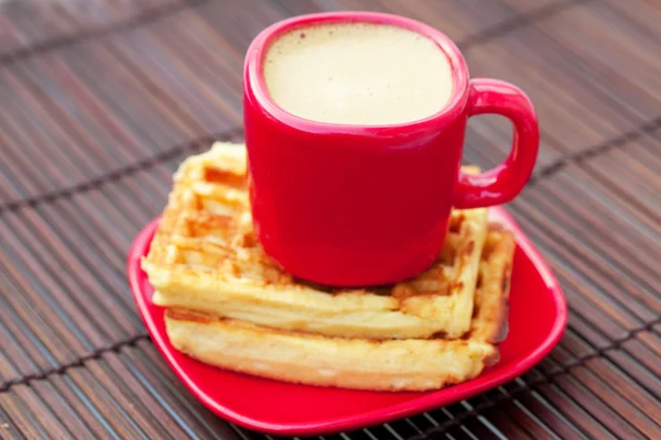 Tasse Cappuccino-Waffeln und Kaffeebohnen auf einer Bambusmatte — Stockfoto