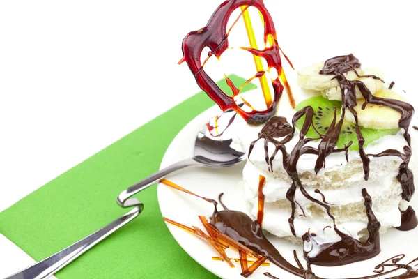 Pastel con crema batida y corazón de caramelo acostado sobre un paño verde —  Fotos de Stock