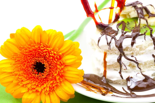 Pastel con corazón de caramelo crema y Gerbera acostado sobre un paño verde —  Fotos de Stock