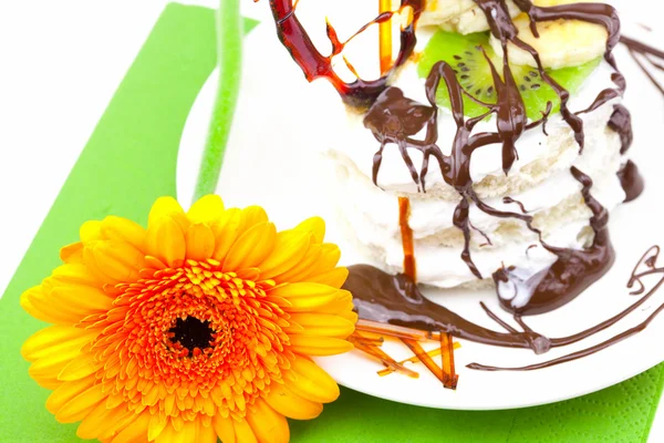 Pastel con corazón de caramelo crema y Gerbera acostado sobre un paño verde — Foto de Stock