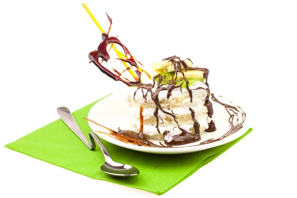 Pastel con crema batida y corazón de caramelo acostado sobre un paño verde — Foto de Stock