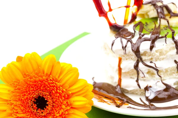 Pastel con corazón de caramelo crema y Gerbera acostado sobre un paño verde —  Fotos de Stock