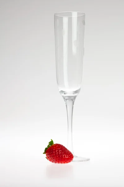 Glas wijn en aardbeien op een grijze achtergrond — Stockfoto
