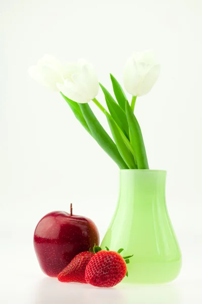 Bílé tulipány váza jablko a jahoda izolovaných na bílém — Stock fotografie