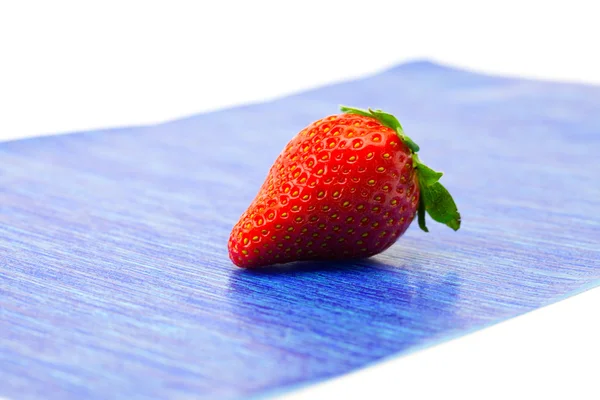 Erdbeeren liegen auf blauem Papier — Stockfoto