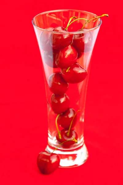 Vaso de cereza sobre fondo rojo —  Fotos de Stock