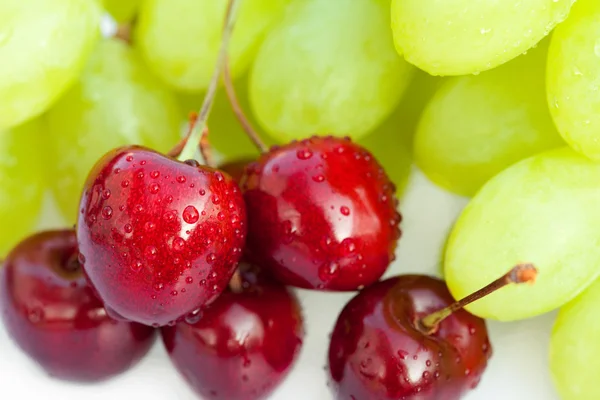 Cherries with drops of water and grapes isolated on white — Stock Photo, Image
