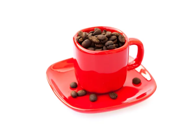 Xícara vermelha com grãos de café isolados em branco — Fotografia de Stock