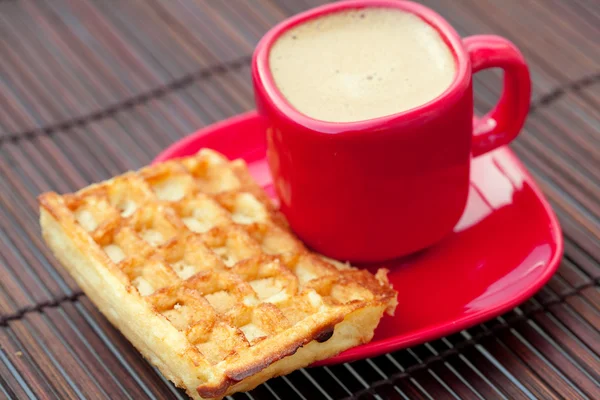 Cup of cappuccino and waffles on a bamboo mat — Stock Photo, Image