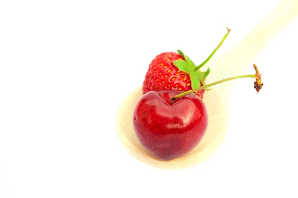 Cereza y fresa en una cuchara aislada en blanco — Foto de Stock