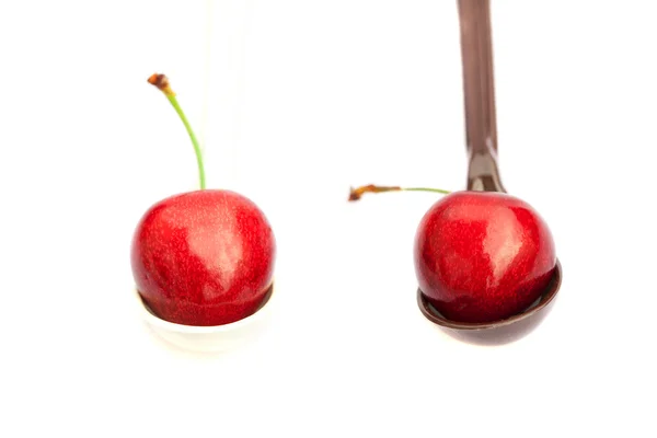 Wiśnia i truskawki w łyżką na białym tle — Zdjęcie stockowe
