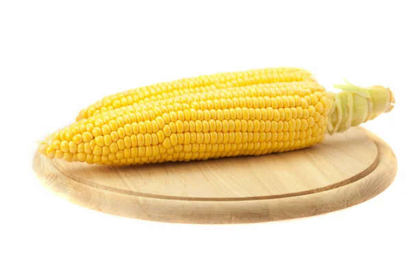 Corn lying on a cutting board isolated on white — Stock Photo, Image
