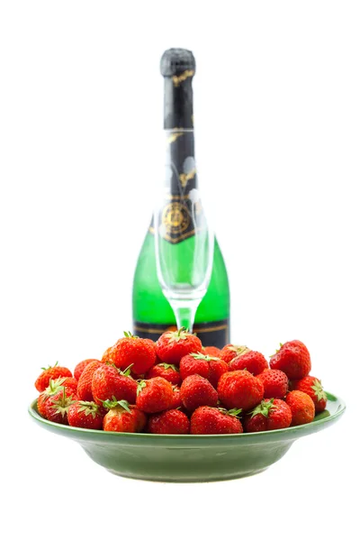 Flaska champagne, glas vin, en tallrik med jordgubbar isolatet — Stockfoto